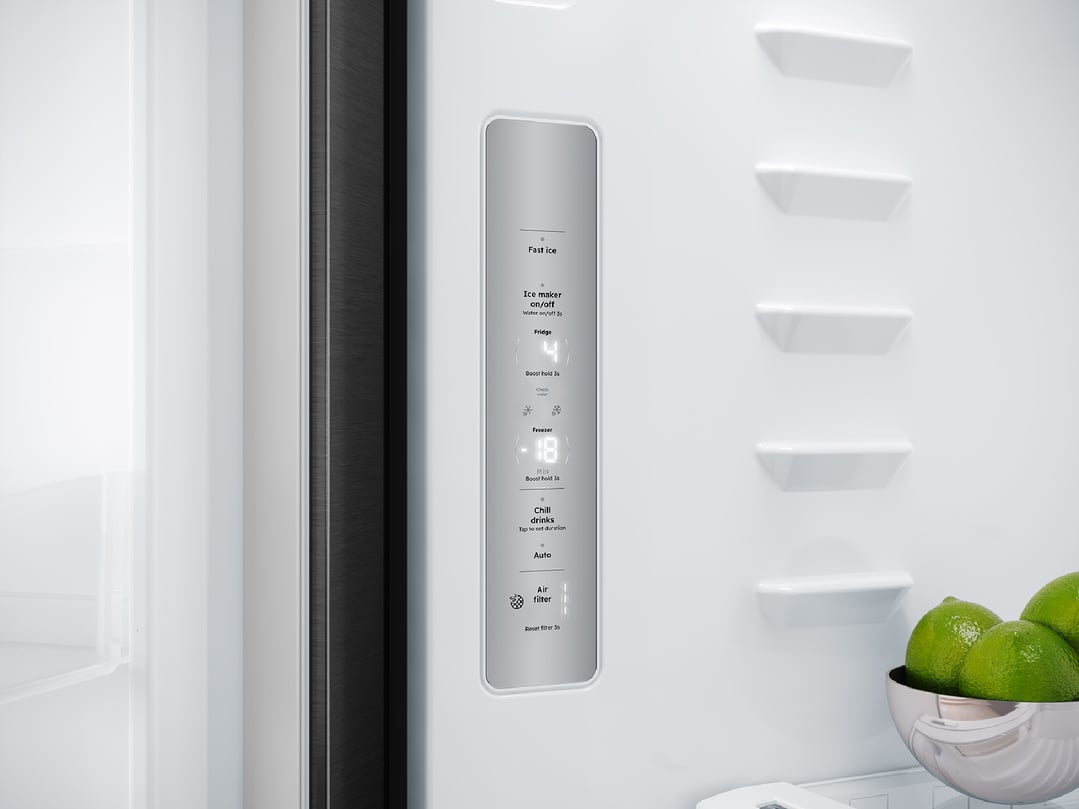 Interior of a fridge showing the control panel and a bowl of limes