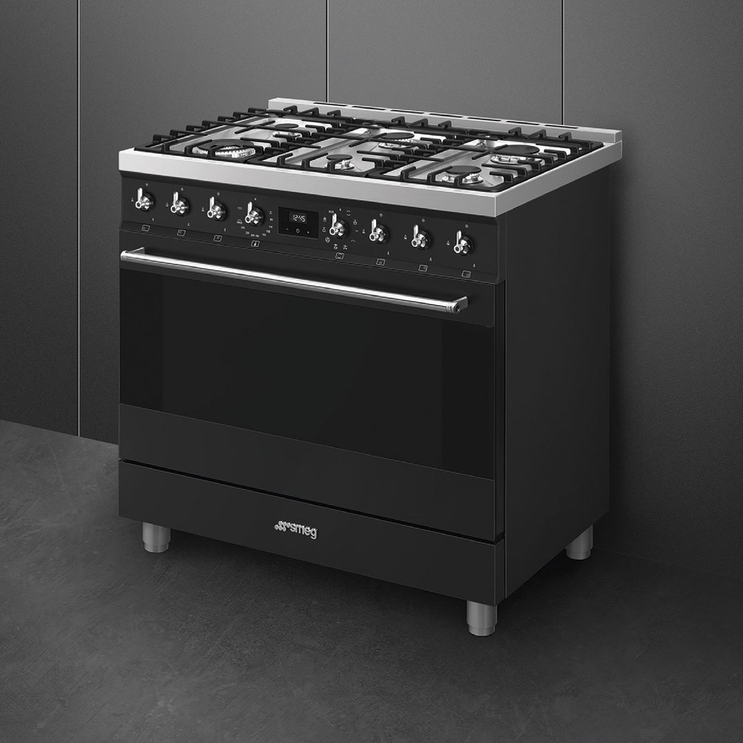 SMEG 90cm 6 burner freestanding cooker in matte black in a dark room