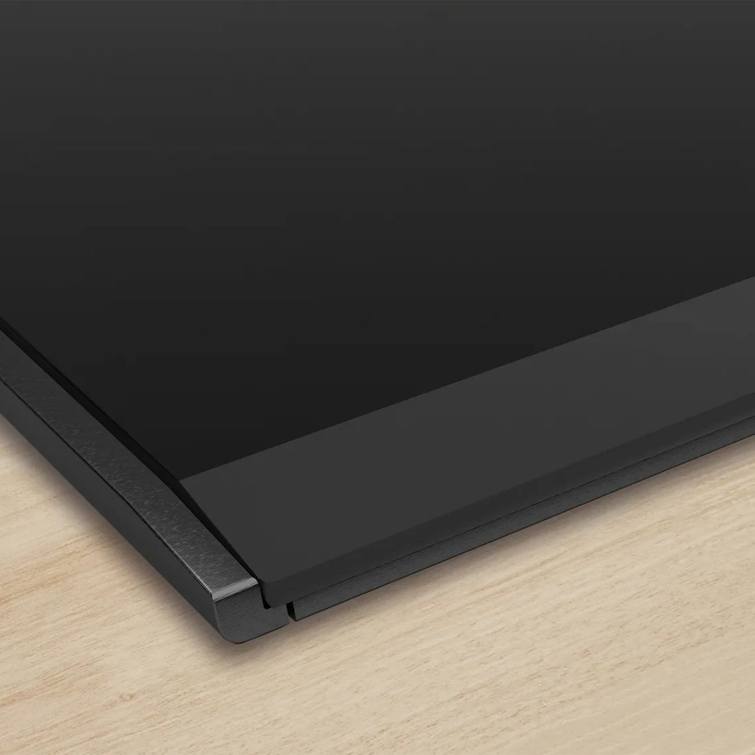 Close-up of a black cooktop on a light wooden countertop