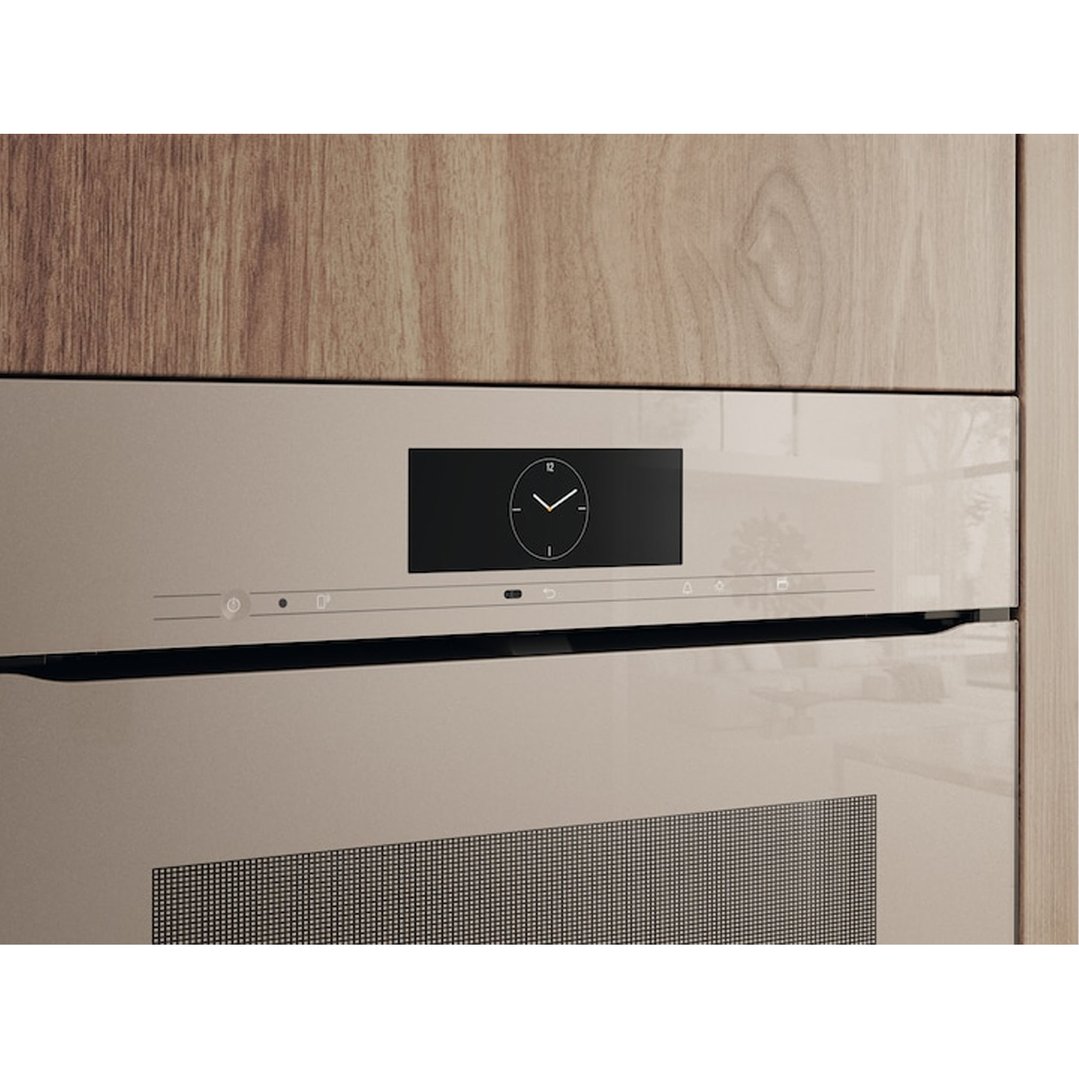 Built-in pearl beige oven with a digital clock display in a wooden kitchen