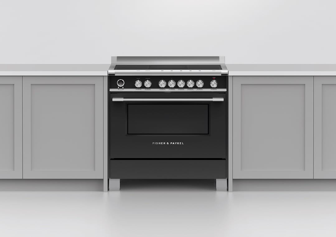 Black induction pyrolytic cooker built into a light grey kitchen cabinet setting