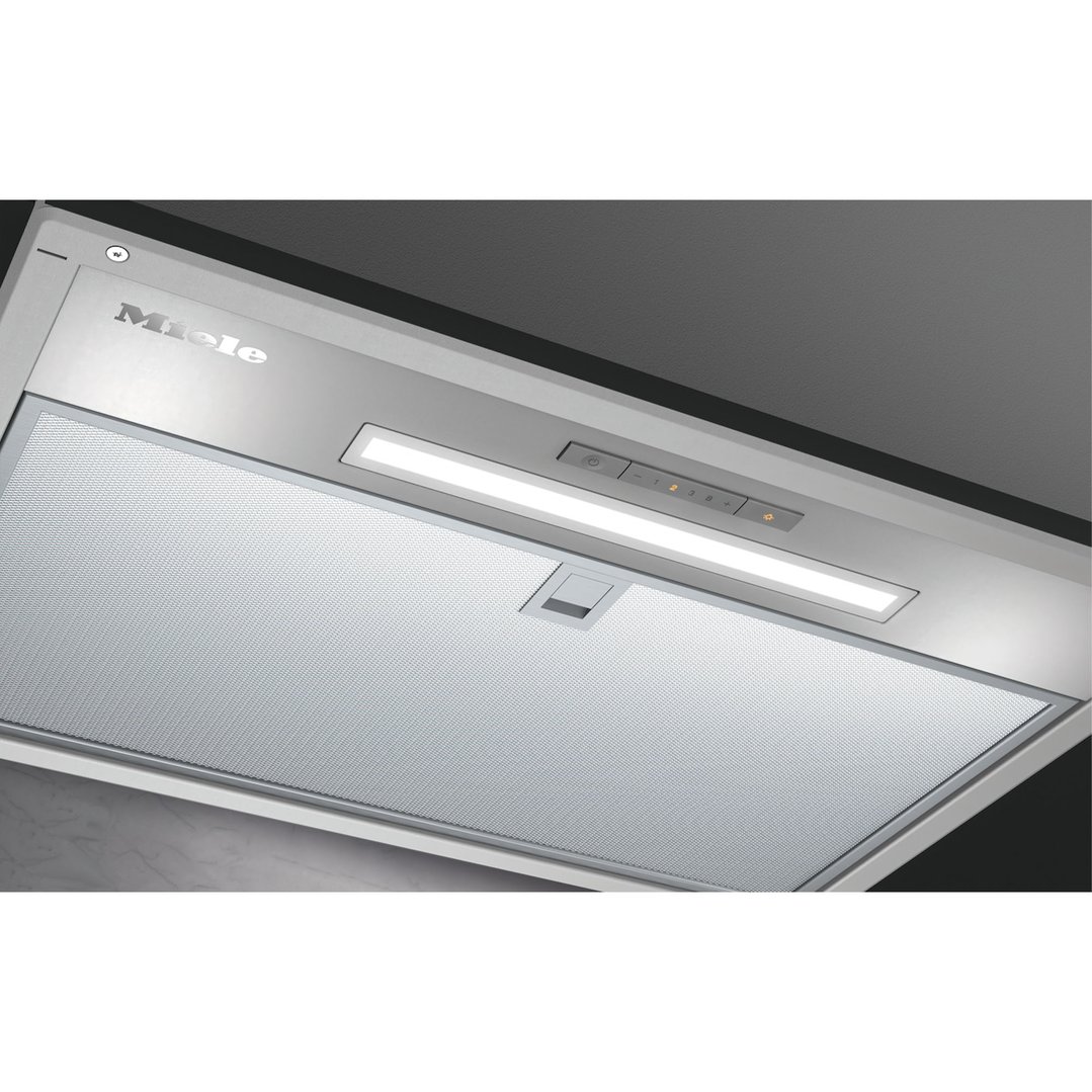 Close-up of an undermount rangehood with controls and LED lighting in a kitchen