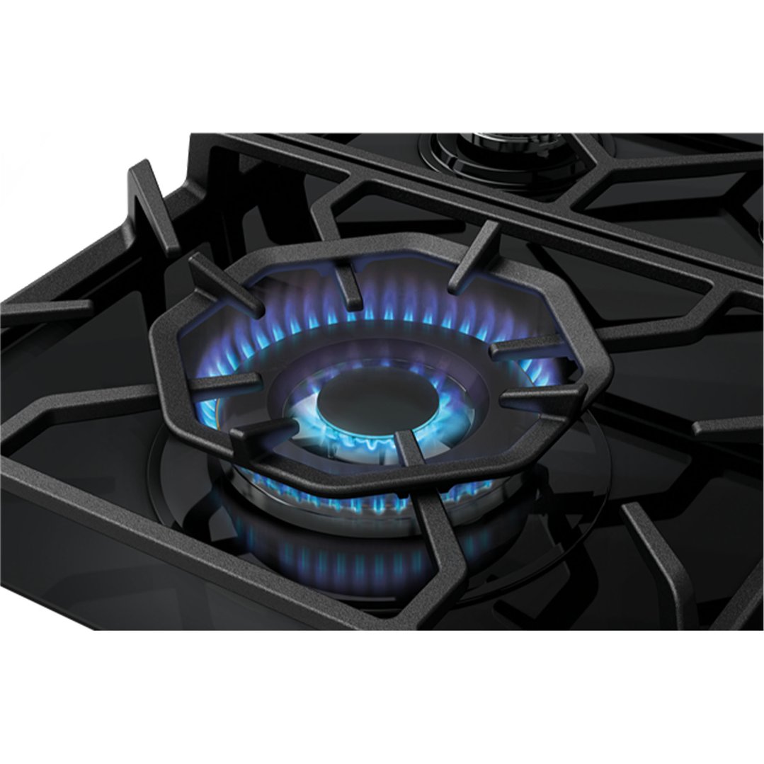 Close up of a gas cooktop burner with blue flames ignited
