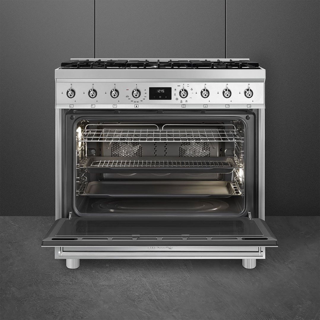 A stainless steel freestanding oven with its door open, showing the interior