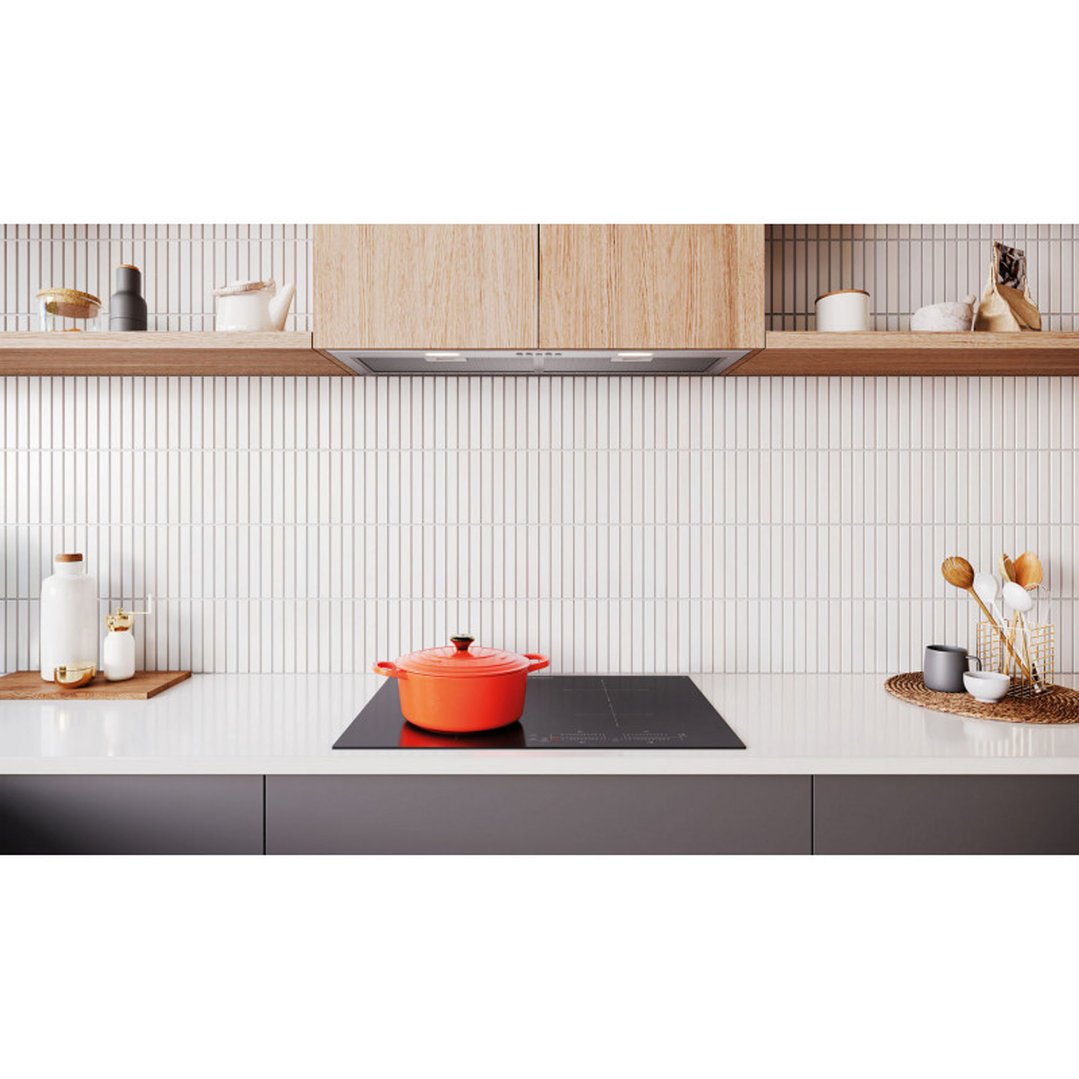 Integrated rangehood in a modern kitchen with a cooktop and orange pot