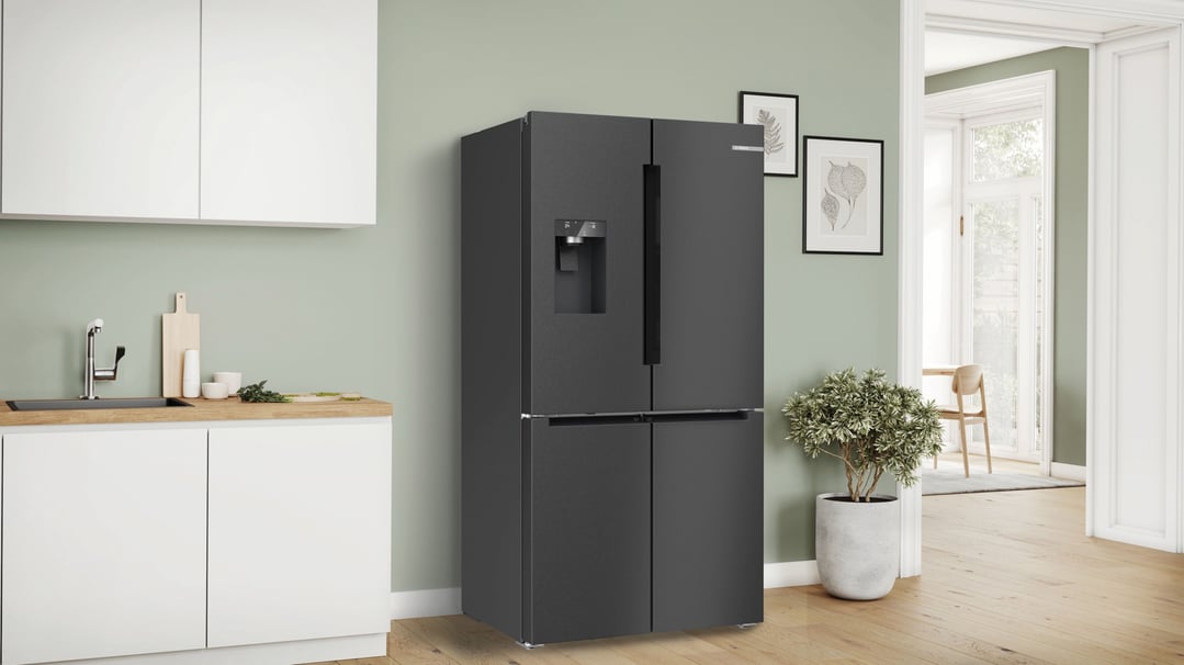 Black steel multi-door fridge freezer in a modern kitchen with light green walls
