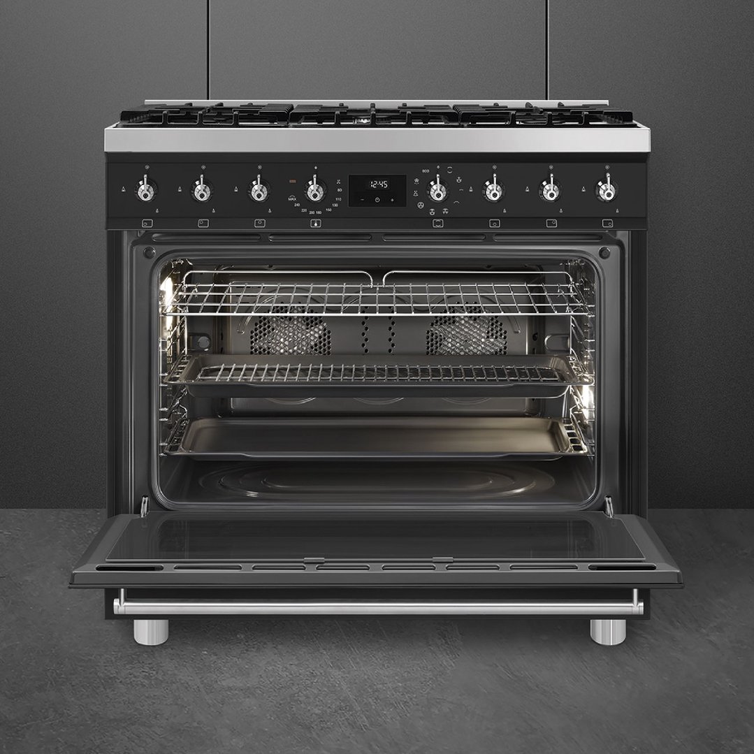 Freestanding pyrolytic cooker with oven door open in a dark kitchen setting