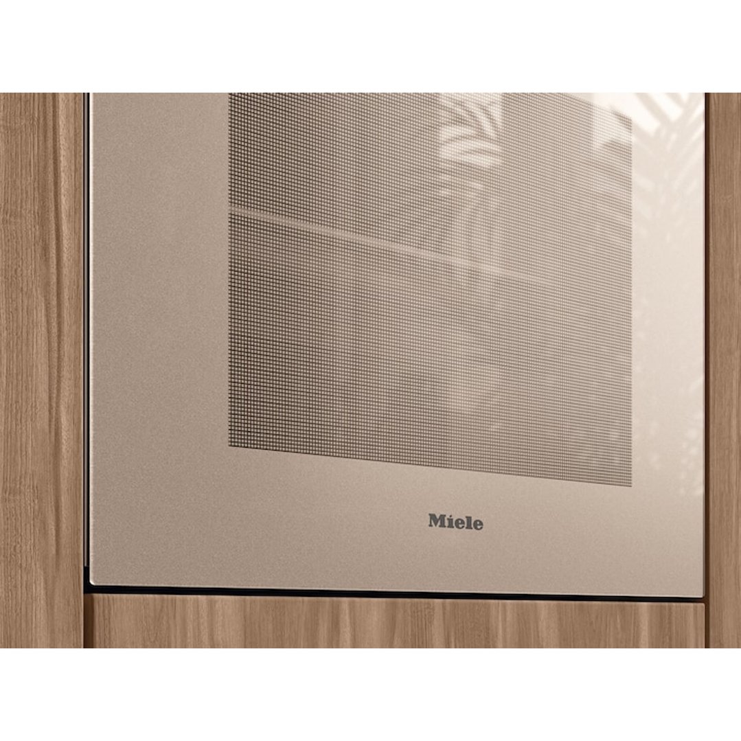 Close up of a pearl beige Miele oven in a wooden cabinet