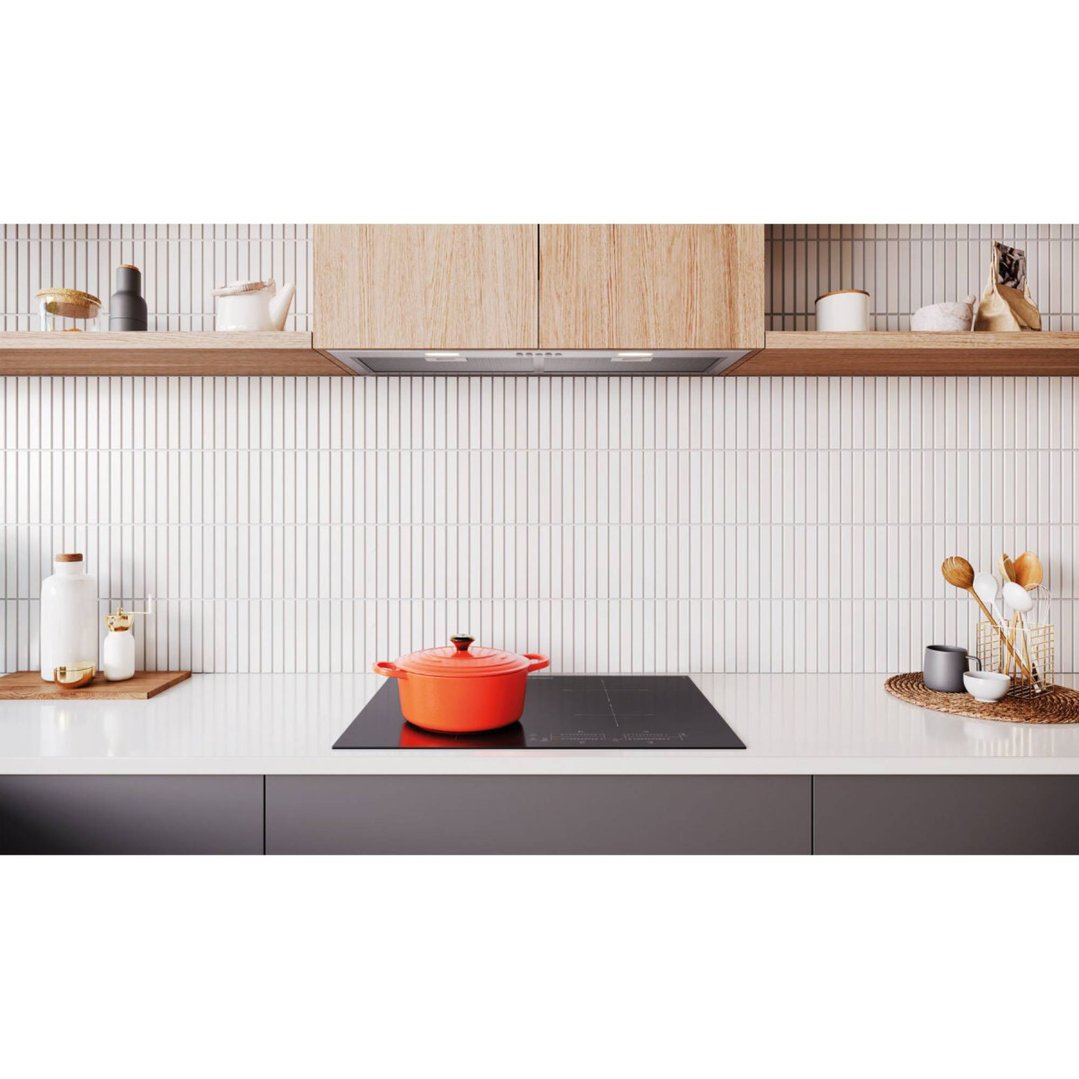 An induction cooktop with an orange pot in a modern kitchen setting