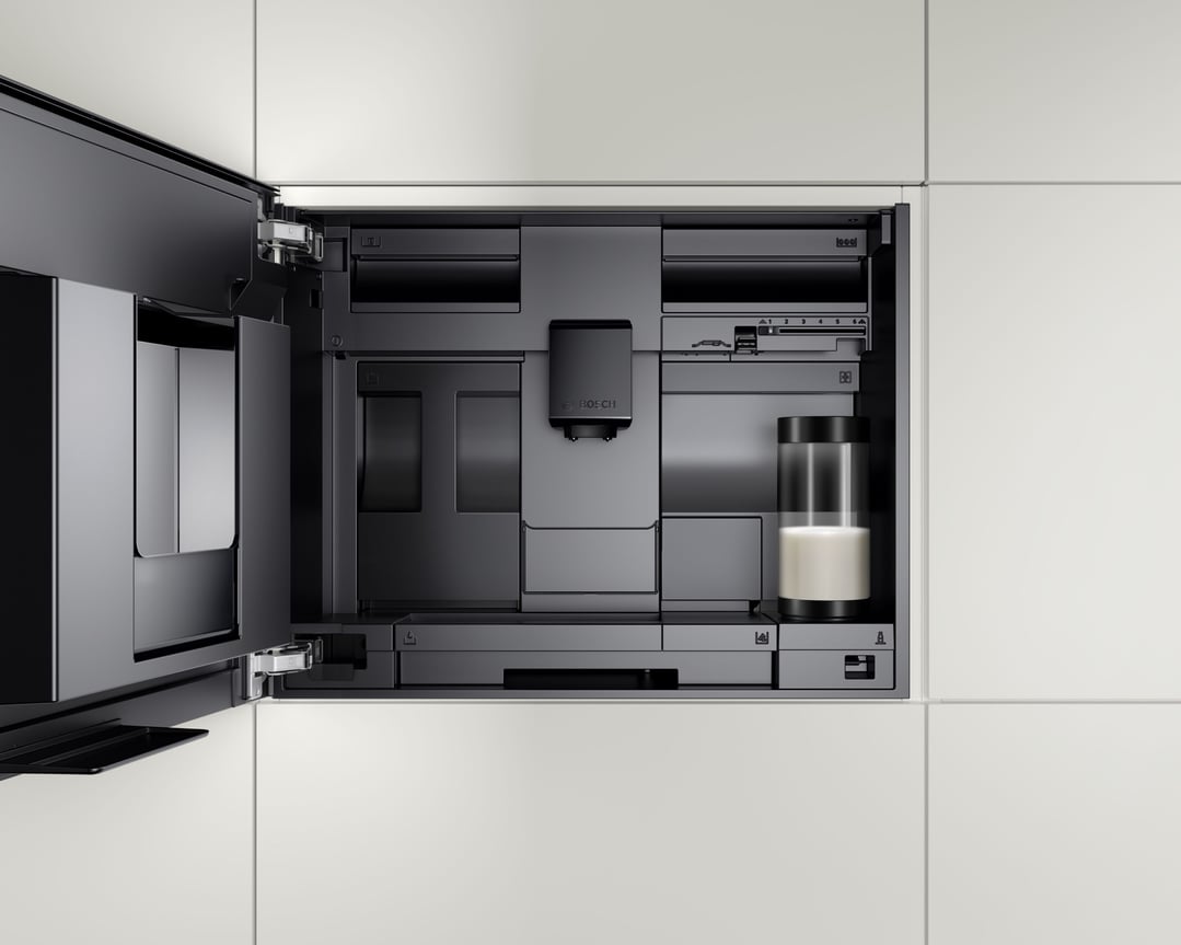 Built-in fully automatic coffee machine with door open, showing interior components and milk container