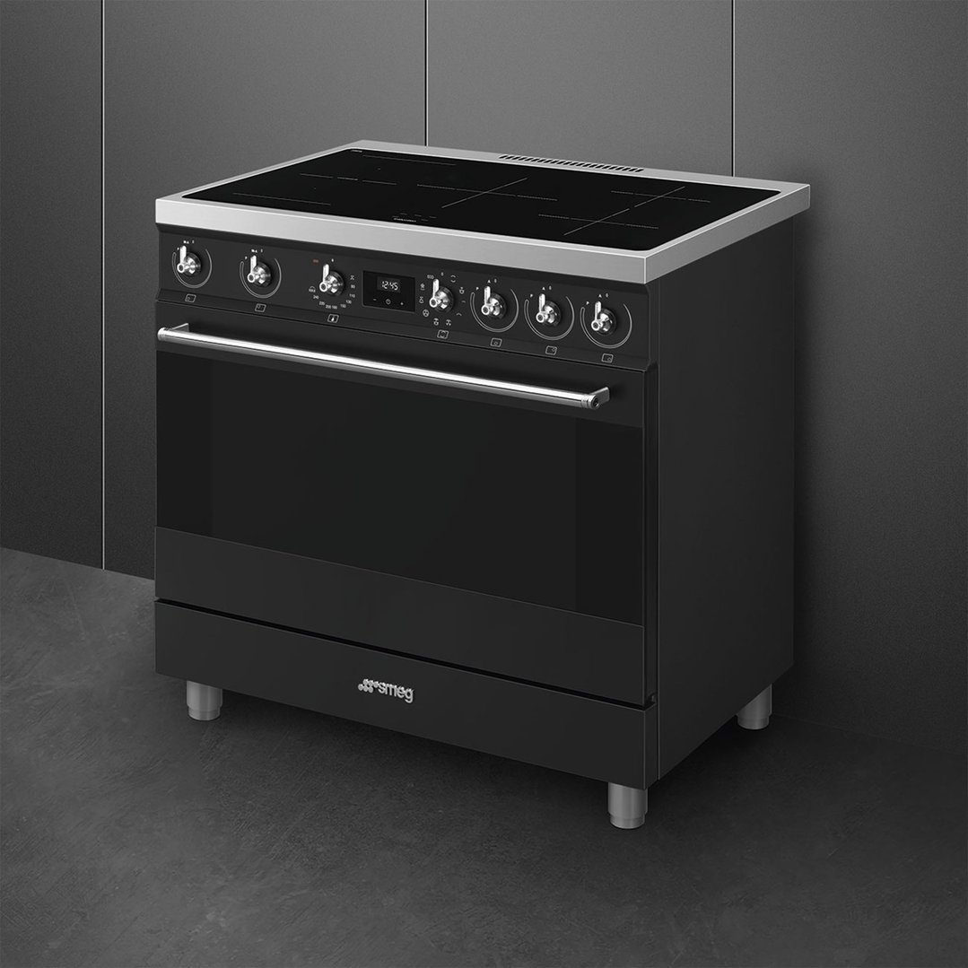 Black freestanding cooker with an induction cooktop in a modern kitchen setting