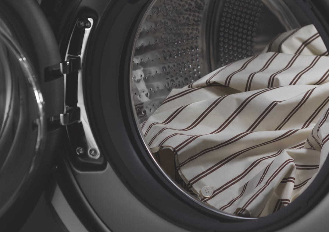 Close up of striped bedding inside the washer dryer combo drum