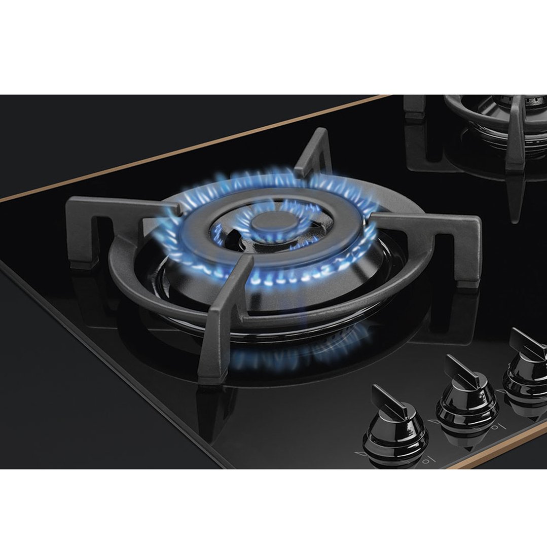 Close up of a gas cooktop burner with blue flames ignited