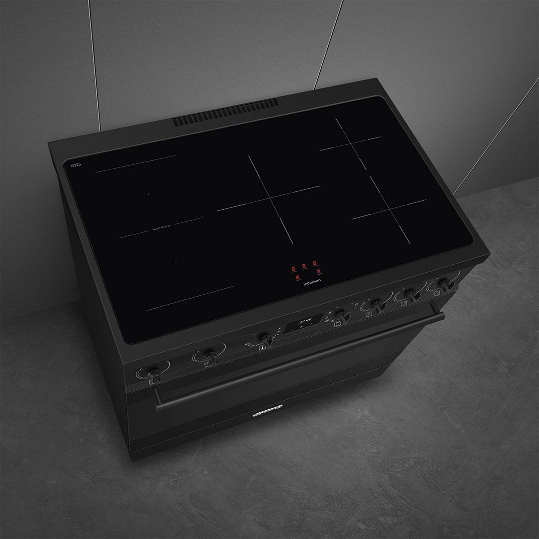 Matte black freestanding cooker with induction hob in a dark kitchen setting