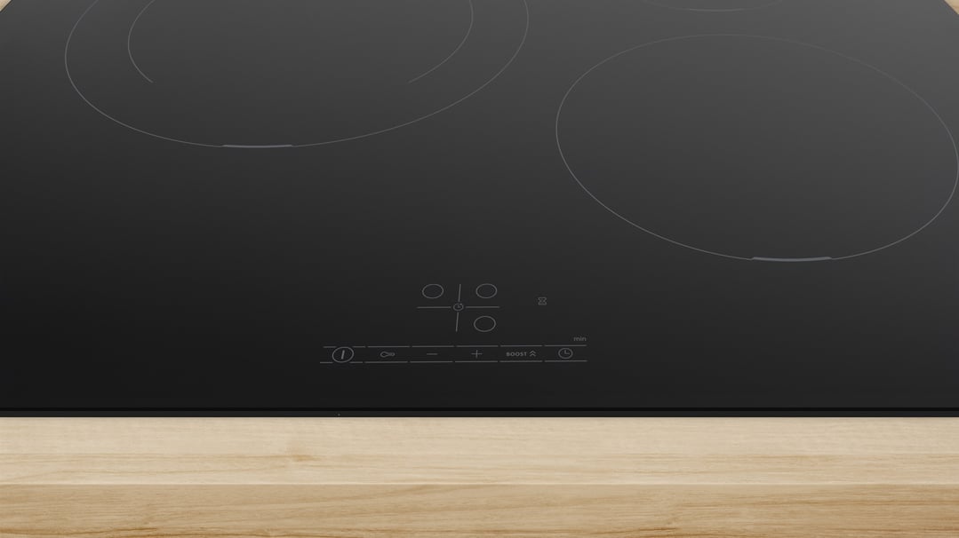 Close-up of a black Bosch induction cooktop on a light wooden countertop