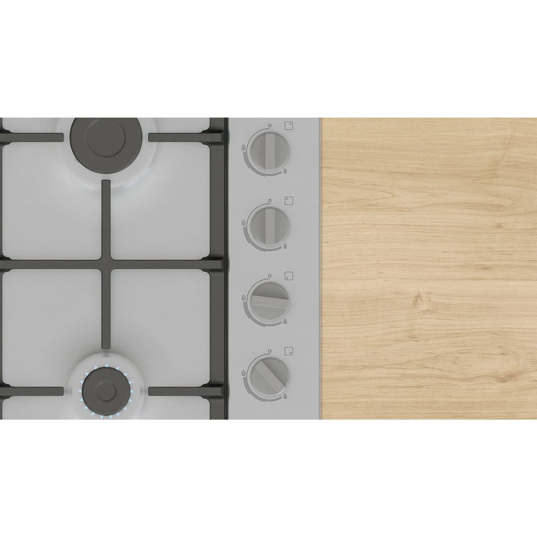 Overhead view of a gas cooktop with one burner lit, next to a wooden countertop
