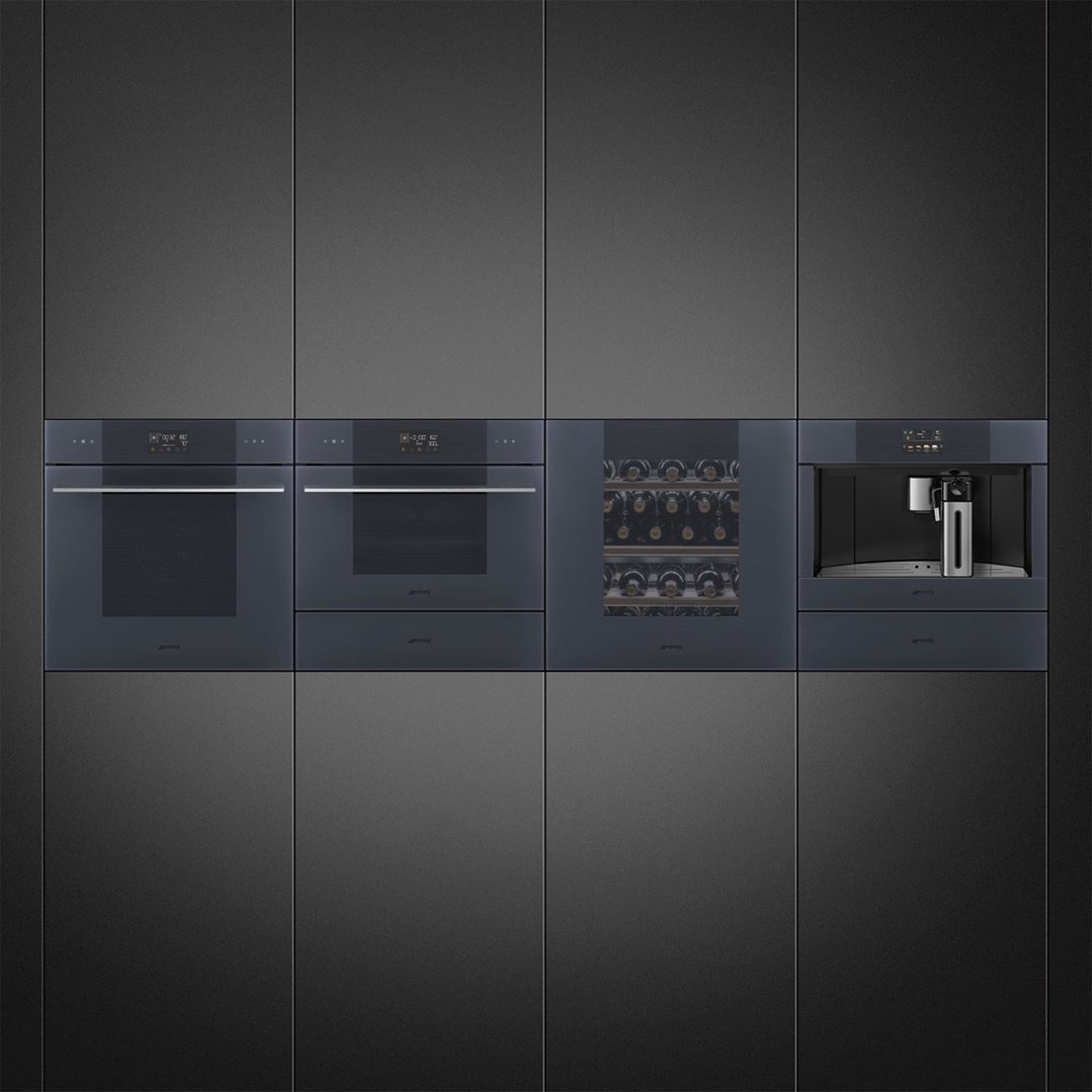 Four built-in appliances, including a coffee machine, in a dark grey kitchen