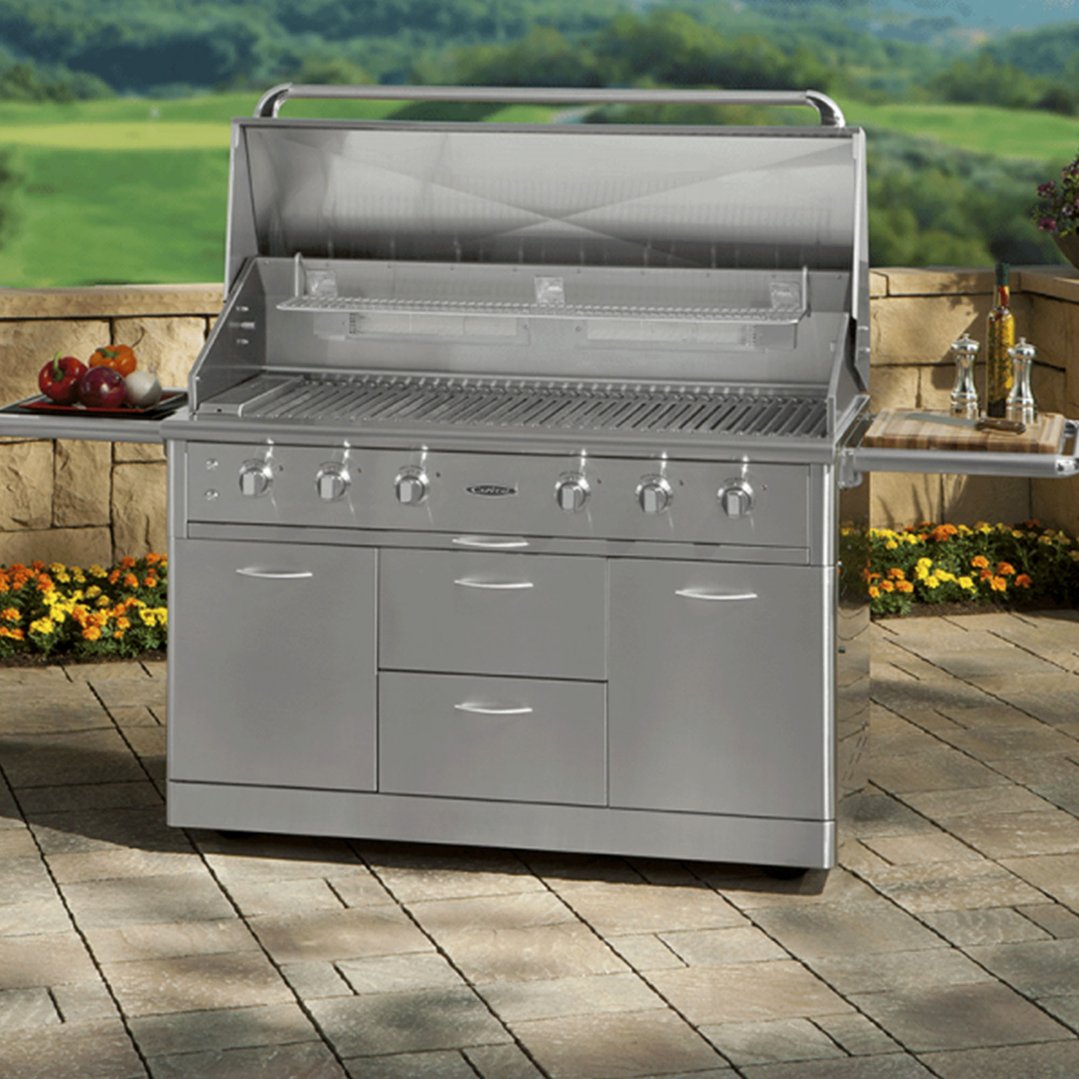 Stainless steel barbeque grill with side tables on a patio with greenery