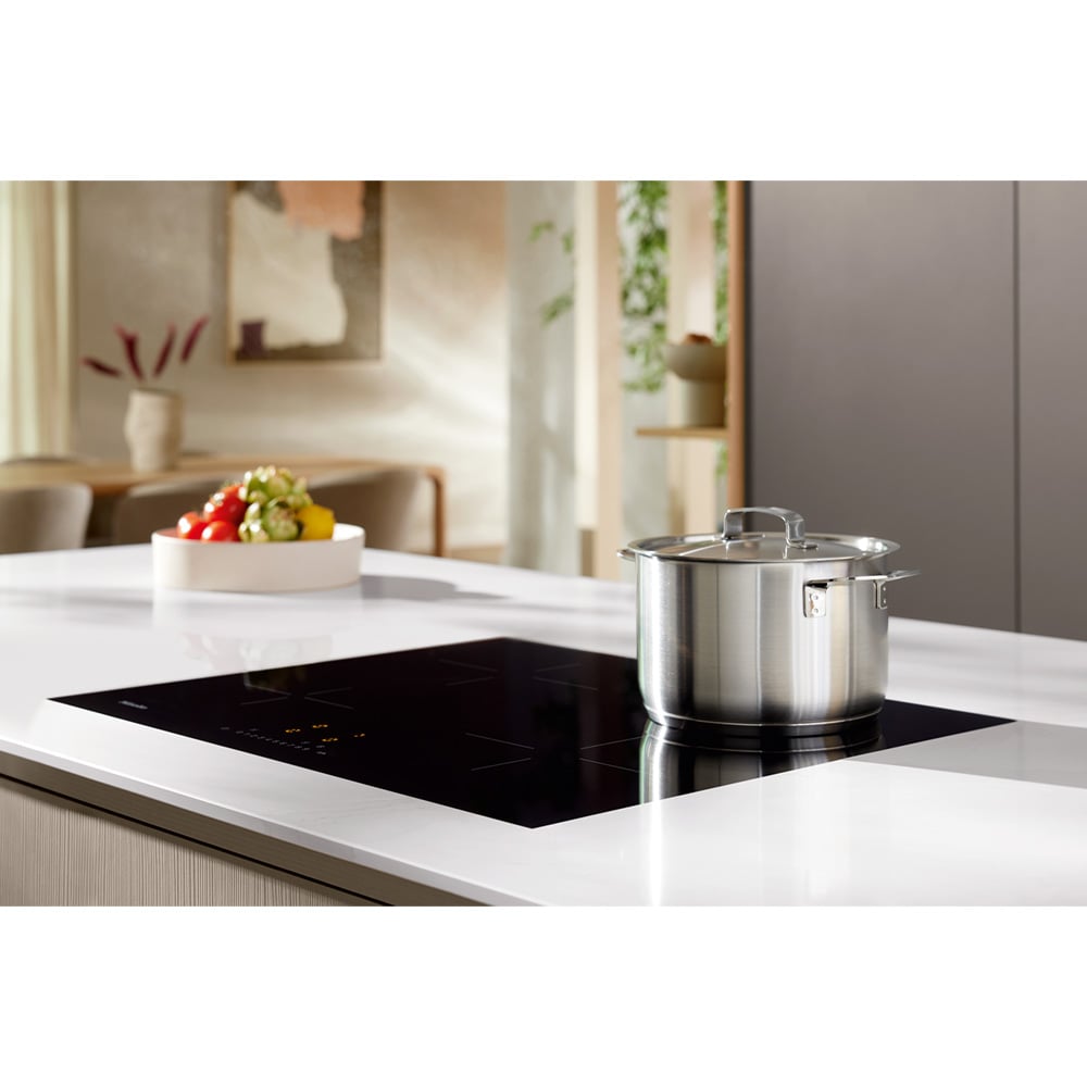 Induction cooktop with a pot on a white kitchen island in a modern kitchen