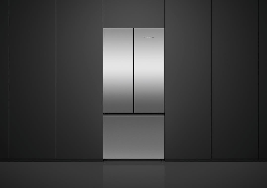 Stainless steel French door refrigerator freezer built into dark cabinetry