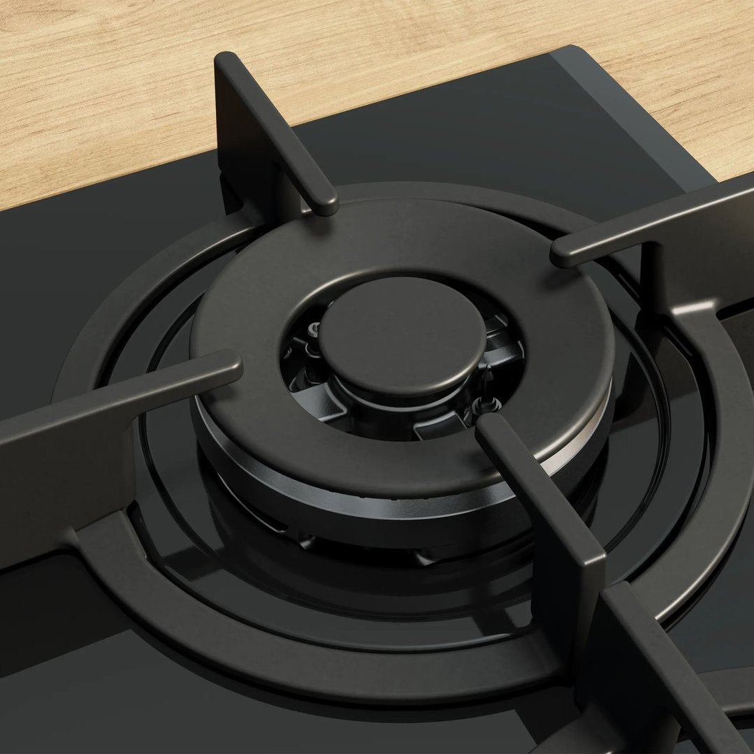 Close-up of a black gas cooktop burner on a wooden countertop