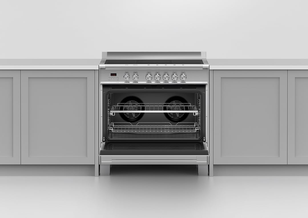 Stainless steel oven with open door and two racks in a kitchen setting