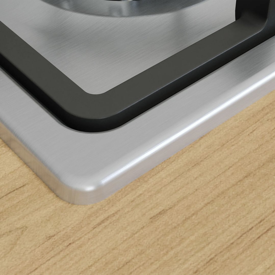 Close up of a stainless steel gas cooktop on a wooden countertop