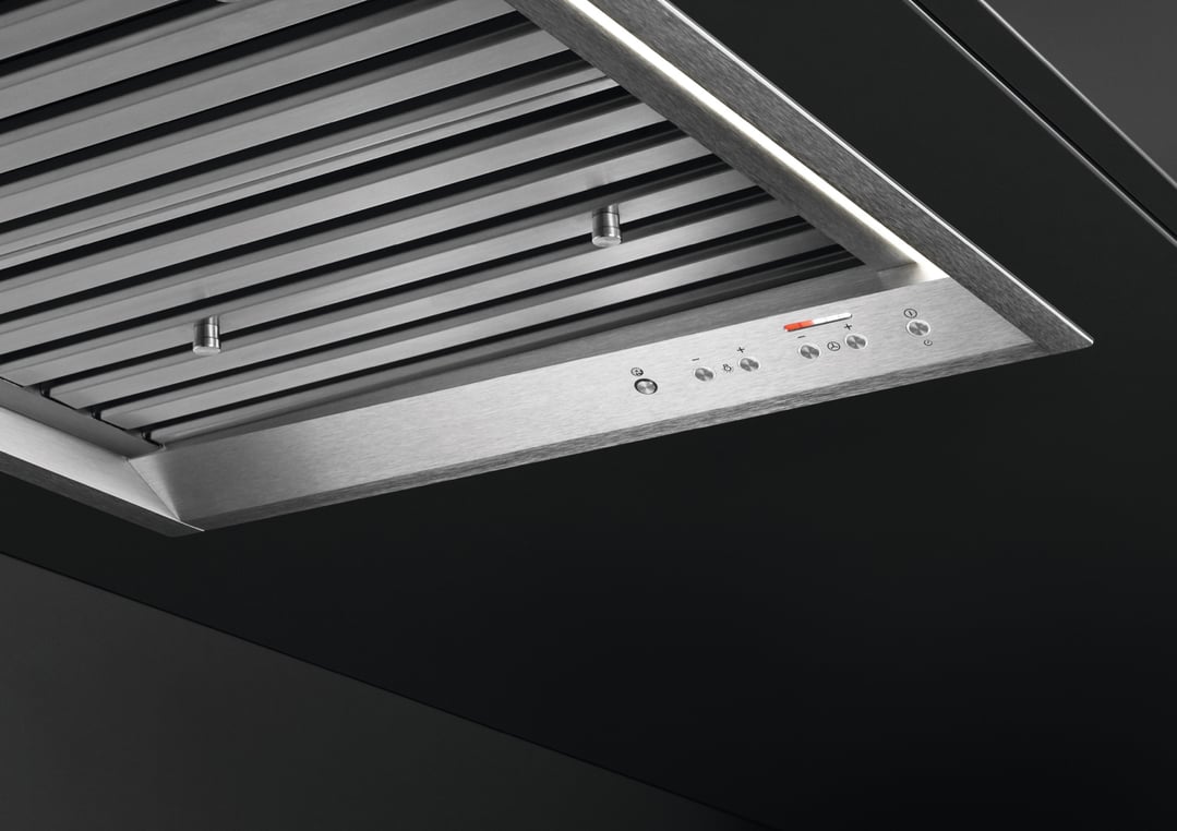 Close-up of a stainless steel rangehood with controls and LED lighting