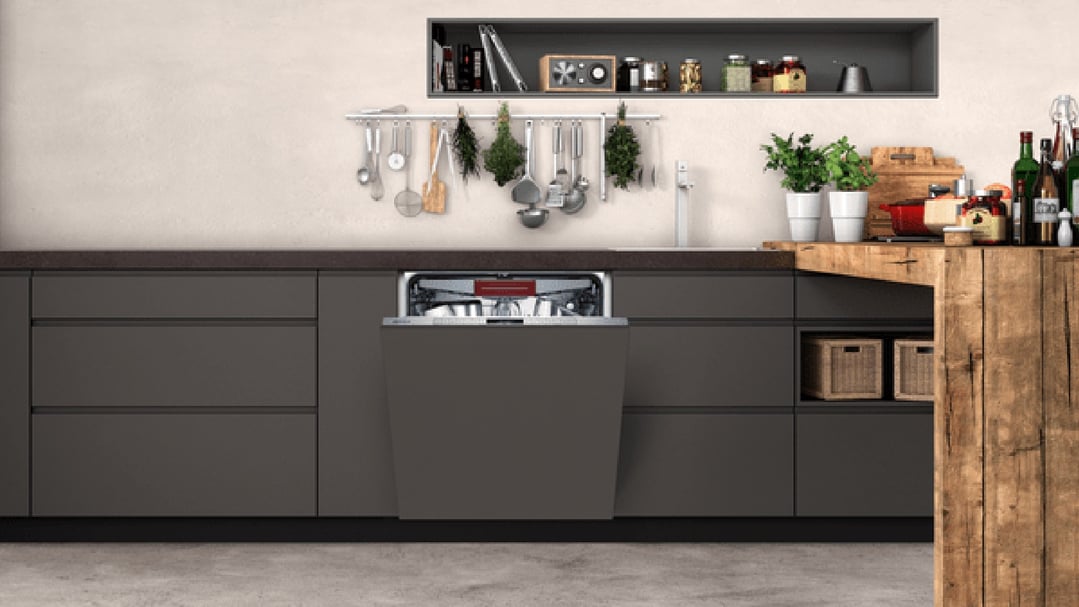 Fully-integrated dishwasher in a modern kitchen with dark cabinets and wooden accents