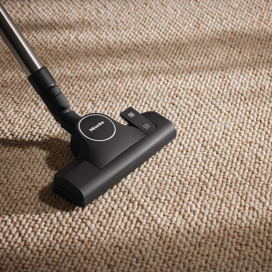 Miele vacuum cleaner floorhead on a textured beige carpet