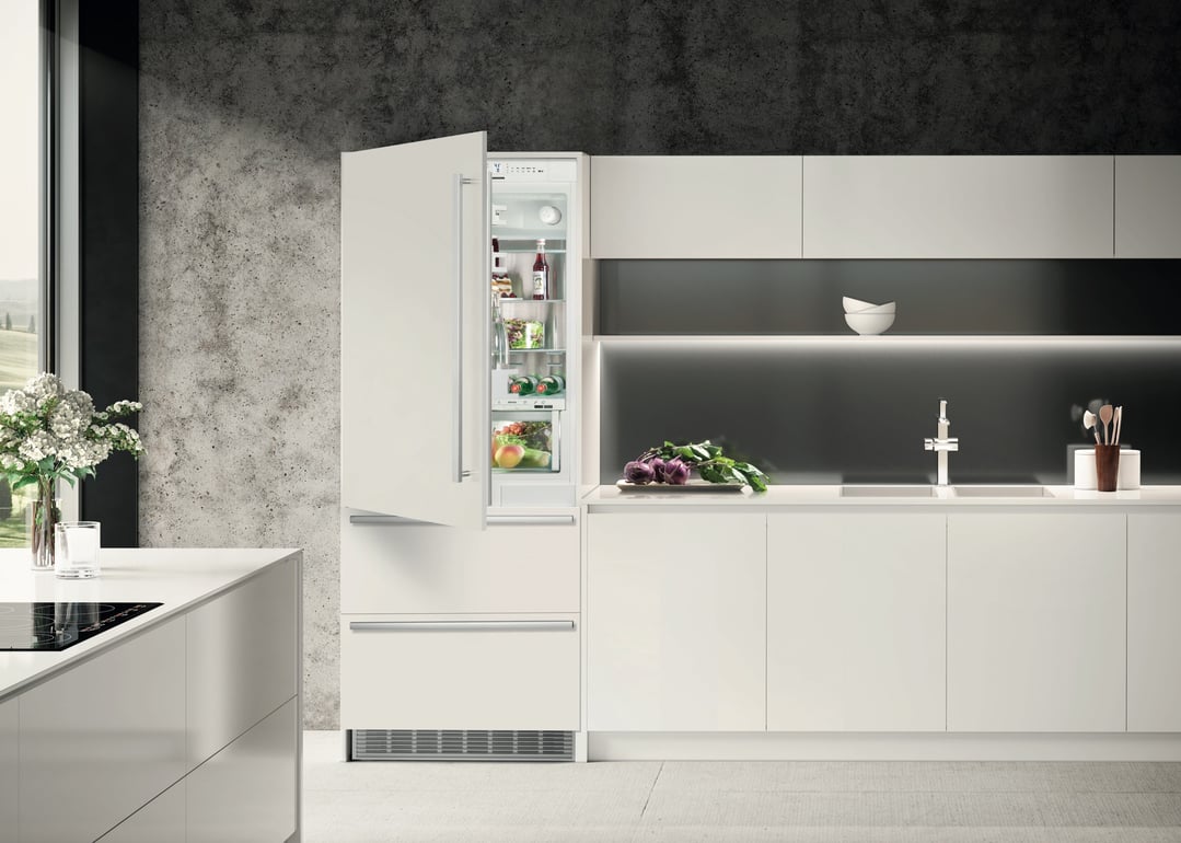 Integrated bottom mount fridge with open door in a modern kitchen setting