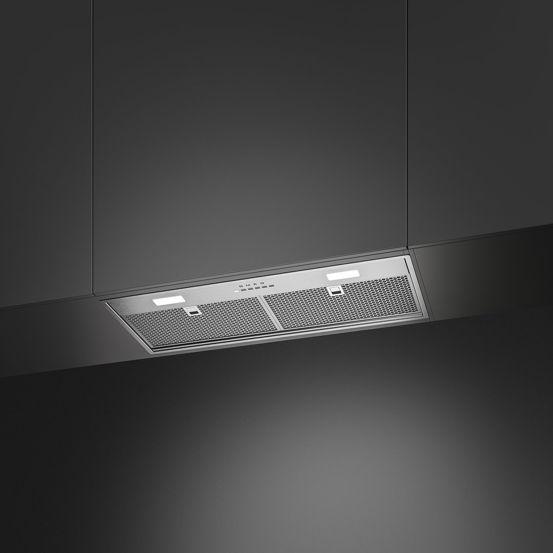 Stainless steel rangehood with lights on, installed under dark grey cabinetry