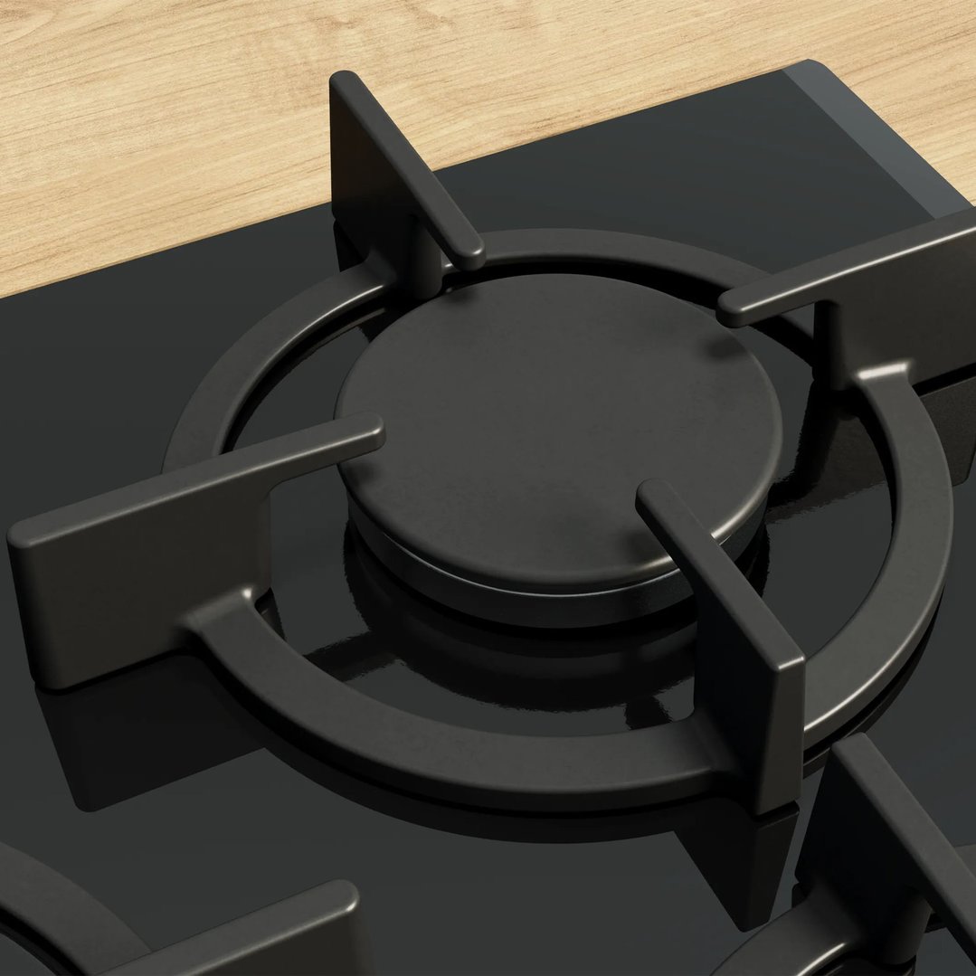Close-up of a black gas cooktop burner on a wooden countertop