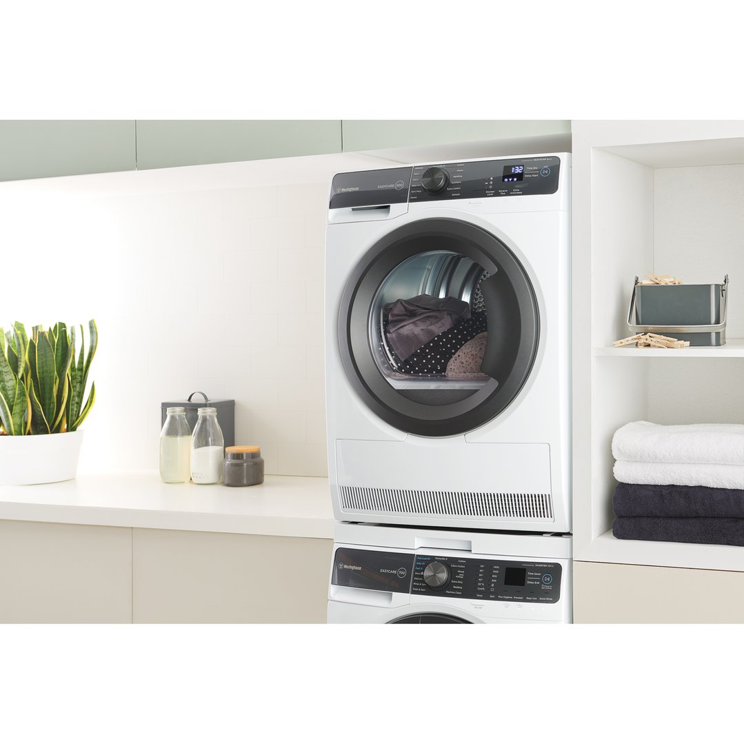 White Westinghouse dryer stacked on a washing machine in a laundry room