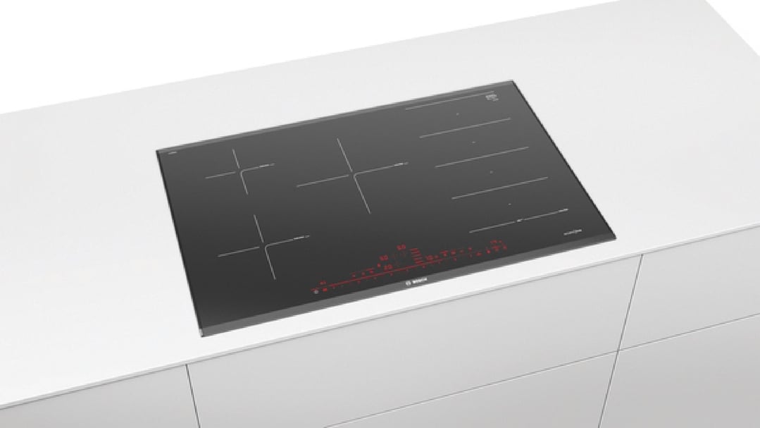 Black Bosch cooktop built into a white kitchen countertop with drawers below