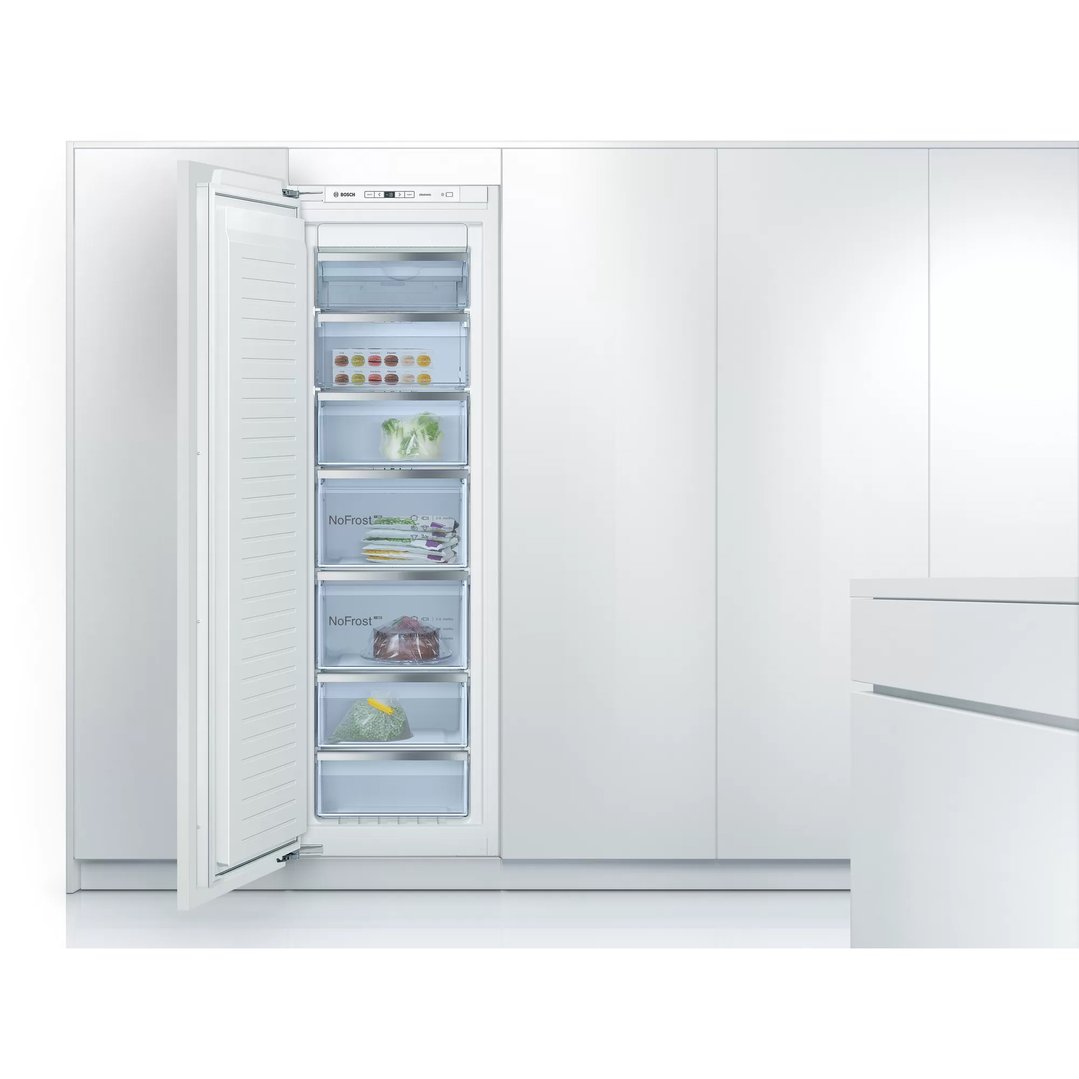 Built-in freezer with door open, showing contents in a modern white kitchen