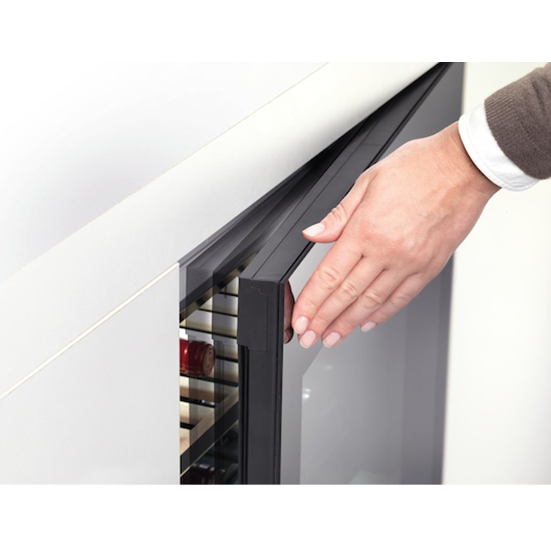Hand opening the door of a built-under wine conditioning unit with two temperature zones