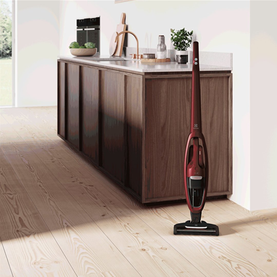 Red Electrolux Well Q7 Animal Cordless Vacuum standing on a wooden floor in a kitchen