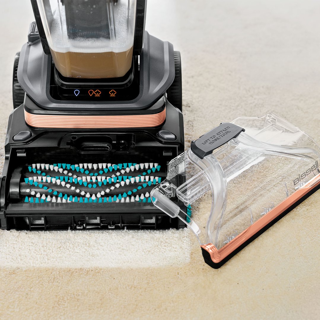 BISSELL Revolution HydroSteam vacuum cleaner cleaning a carpet, showing dirty water
