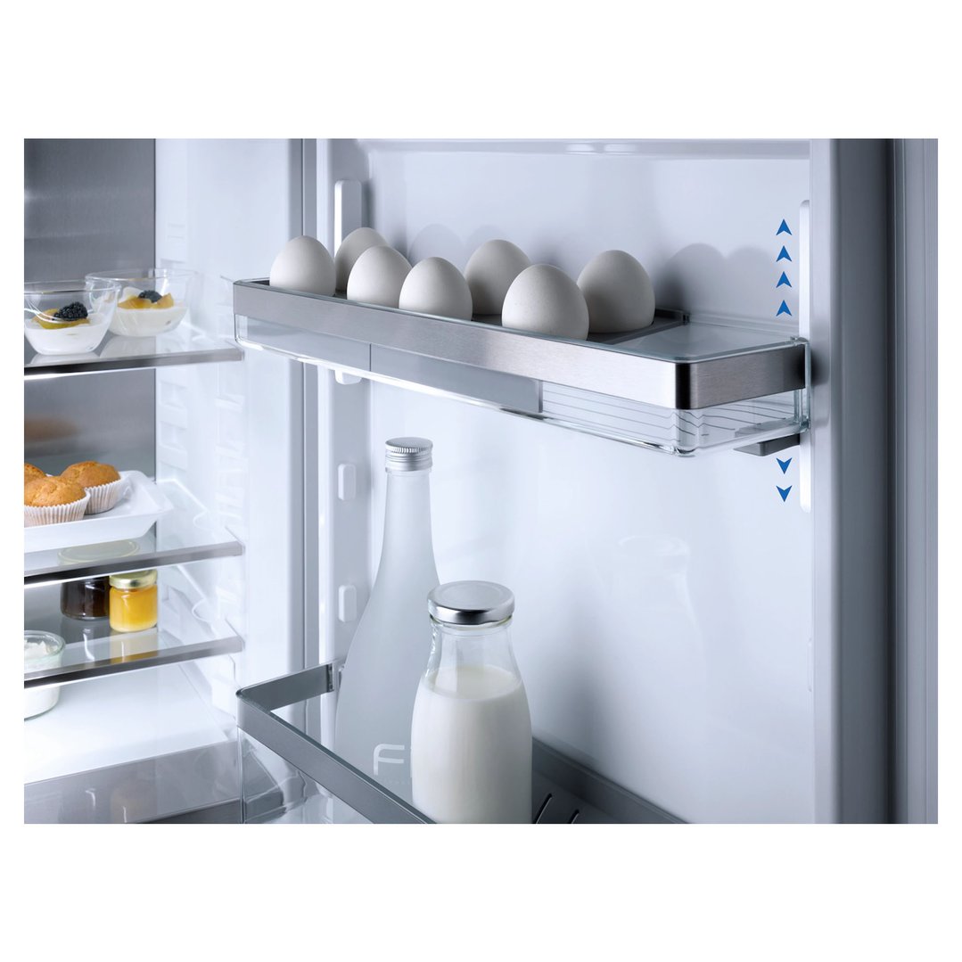Interior view of a fridge with food items on shelves and in door