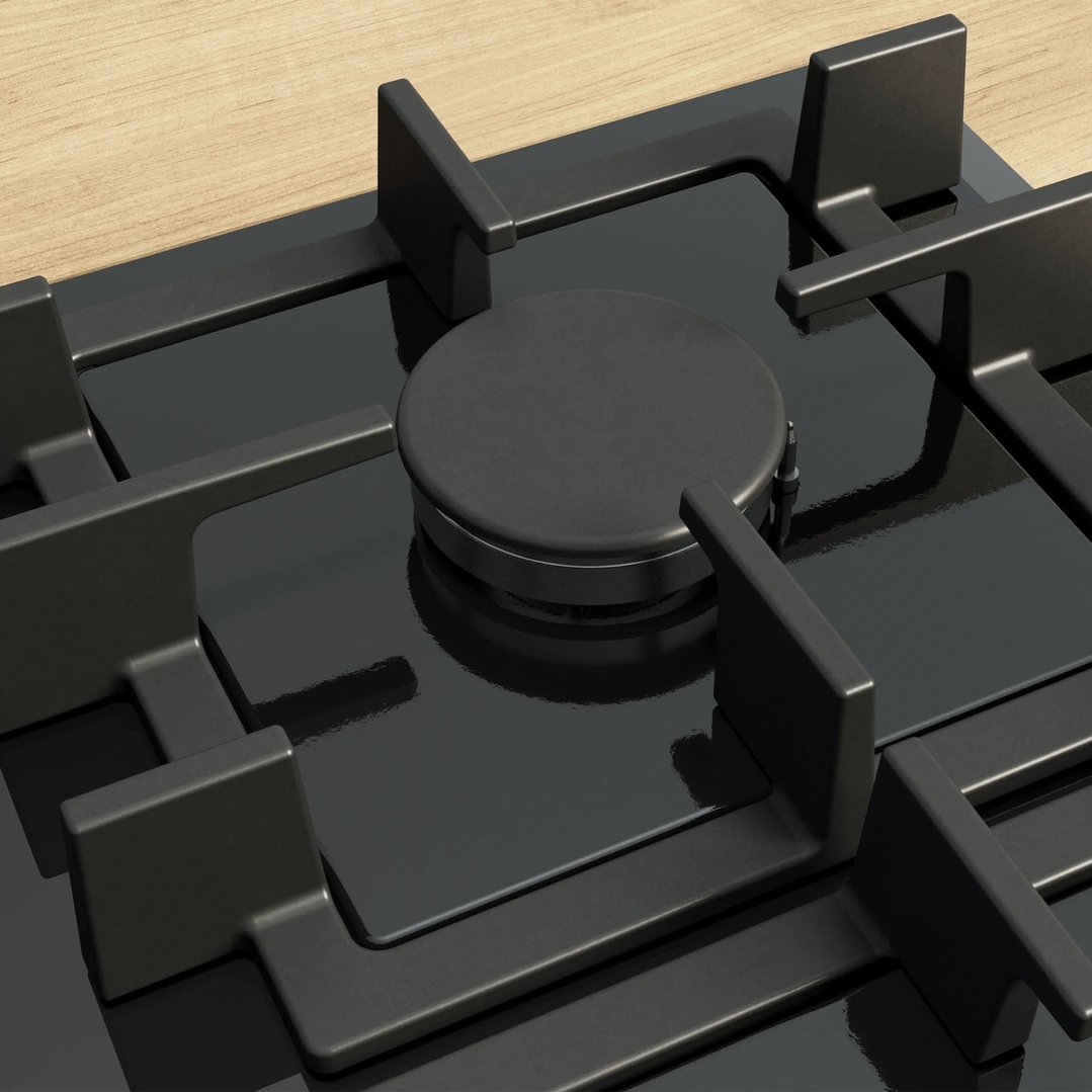 Close up of a black gas cooktop with a single burner on a wooden countertop