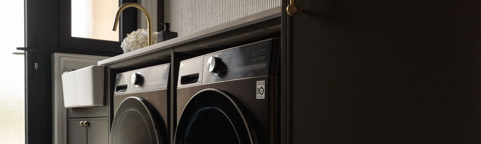 An aesthetic black laundry featuring an LG washer and dryer side by side.
